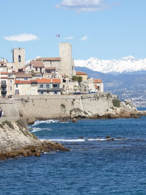 La vieille ville d’Antibes et ses remparts face à la mer, les Alpes enneigées à l’horizon